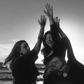 Untitled (Right to Left) Julien Baker, Lucy Dacus, and Phoebe Bridgers each lifting one hand to the sky.