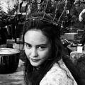 Actress Courtney Eaton staring into the camera with a crown made of twigs on her head.